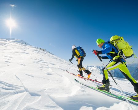 Cross country skiing team couple of men towards the summit of th